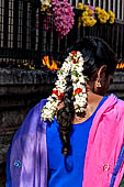 Scented garlands of fresh flowers swaying in women black hair near the Swamimalai temple. 